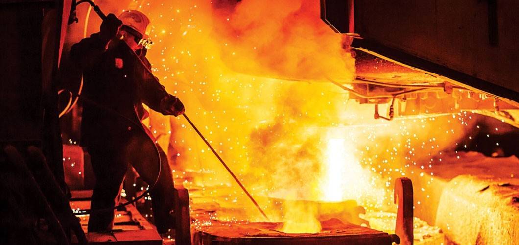 A worker uses an electric furnace to make steel