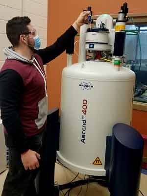 Utica University chemistry student Thomas Labayewski loads a sample in an NMR instrument. 