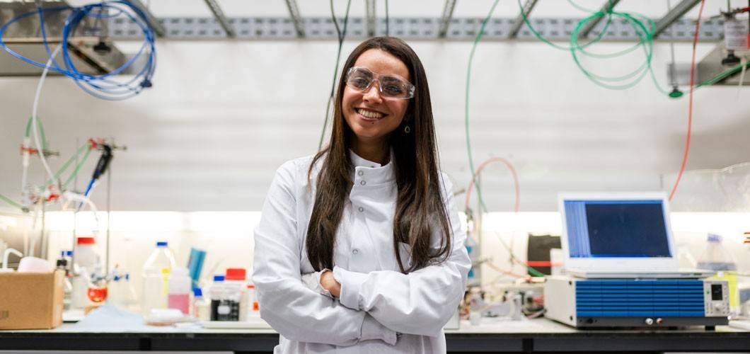 Student smiling standing in a lab